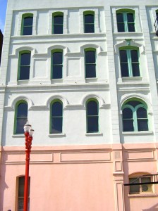 Green and pink building with red lamp post.
